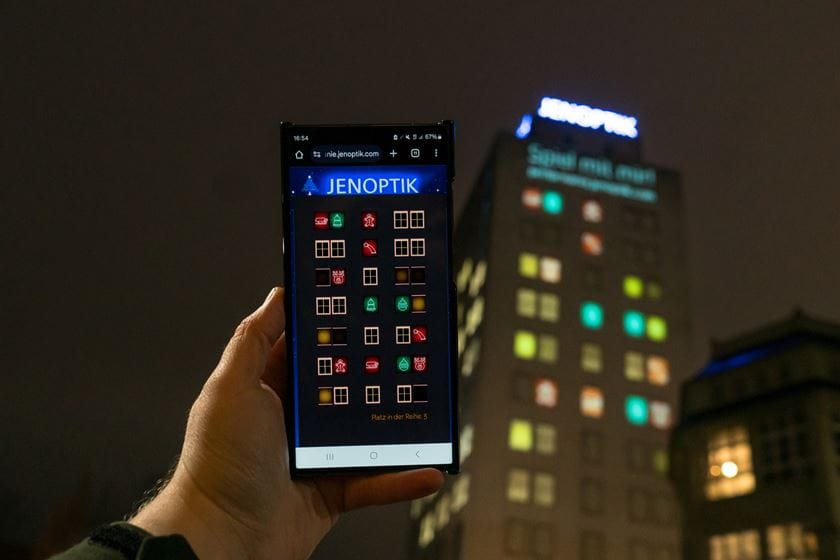 Hand mit Mobiltelefon und Spiele-Ansicht für "Paare finden" am Ernst-Abbe-Hochhaus
