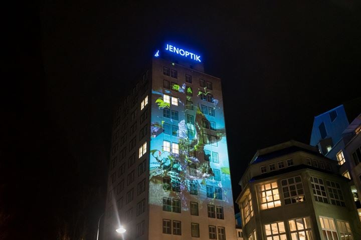 Jenoptik-Gebäude bei Nacht mit Videomapping-Show namens "Florescendi" von Sabrina Ratté