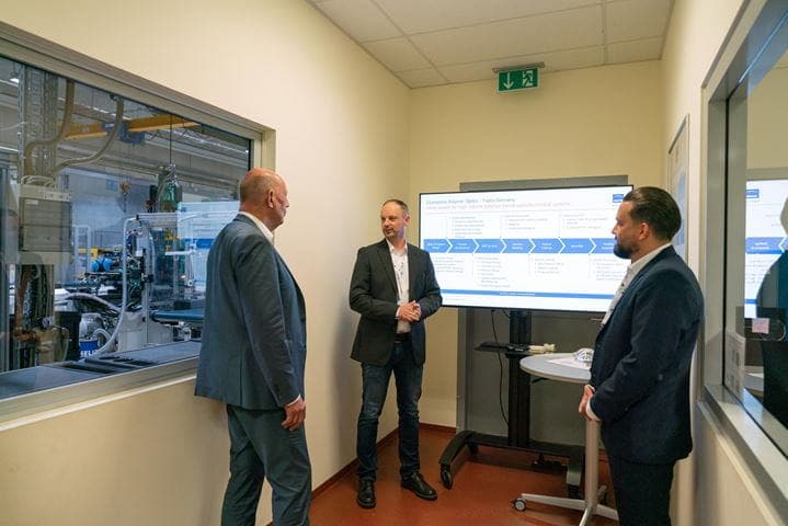 Wirtschaftsminister Tiefensee und zwei Jenoptik-Mitarbeiter vor einem großen Monitor