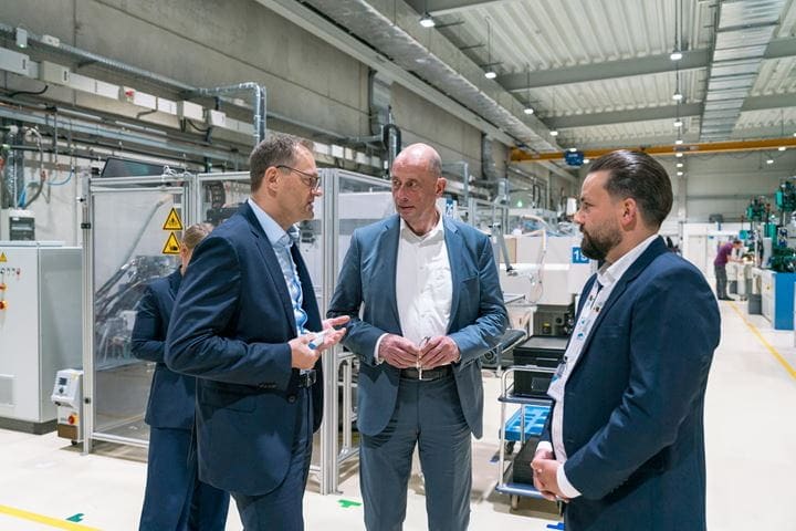 Jenoptik-Chef, Wirtschaftsminister und Standortleiter sprechen miteinander
