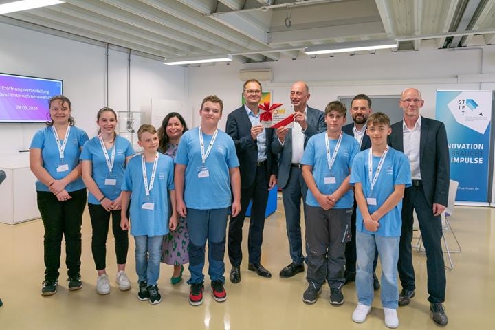 Gruppenfoto mit Schülern und neuer Plakette für die Werkstatt