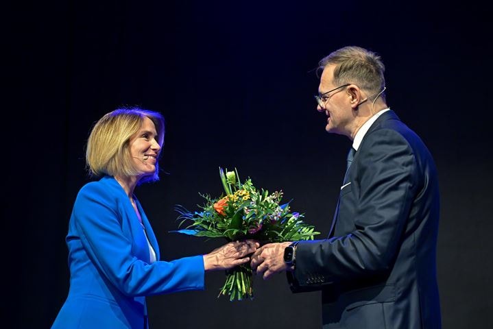 Moderatorin erhält Blumenstrauß von Jenoptik-Chef Stefan Traeger