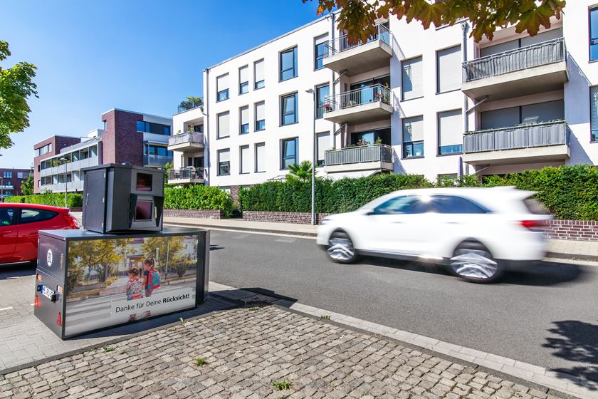 Semistation am Straßenrand, während ein weißes Fahrzeug vorbeifährt